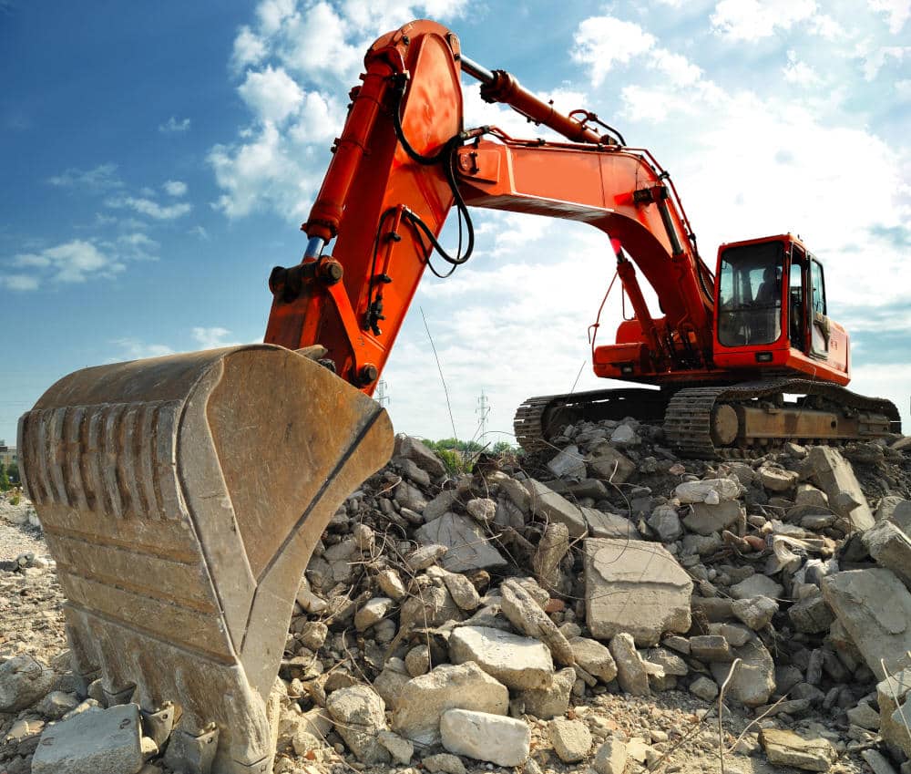 Crawler excavator on demolition site. Front view of a big crawler excavator working on demolition site.