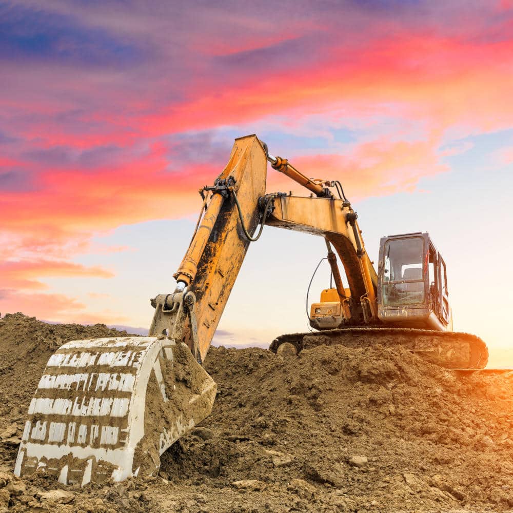 excavator in construction site on sunset sky background